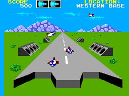 A top-down 3D perspective view of a missile defense scenario shows a gray concrete platform or landing pad in the center foreground. Two white player-controlled vehicles with crosshairs sit on the platform facing forward. Purple mountains with snow peaks line the horizon on either side. A blue sky fills the upper portion with a small white enemy aircraft visible. The score display reads "SCORE" and "LEVEL" in the top-left corner with numeric values shown. Green grass terrain extends to both sides of the central gray structure. The sprite-based graphics use a limited 8-bit color palette typical of Sega Master System hardware.