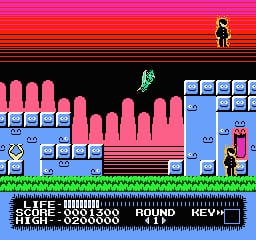 A colorful NES-era platformer level features a young character standing on green grass in the lower-left area. Pink and blue block platforms form a path upward through the center, with a green enemy sprite visible mid-screen. The background displays a pink and black gradient sky with horizontal scan lines typical of 8-bit graphics. A blue informational panel spans the bottom of the screen, and a small character sprite appears in the upper-right corner against the gradient backdrop.