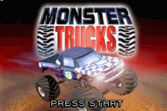 The Monster Trucks title screen displays the game's logo in large gray and red text at the center, with a stylized tire tread pattern flanking both sides. Behind the logo, a blue monster truck is shown mid-jump over sandy terrain with red dust clouds. The background features a reddish-orange gradient sky. At the bottom of the screen, white text reads "PRESS START" in a simple sans-serif font. The overall image uses a limited color palette typical of GBA hardware, with visible pixelation and the low resolution characteristic of the platform.