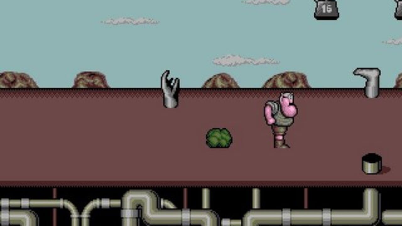A character in pink and brown clothing stands on a brown underground platform against a light blue sky with white clouds. A green shrub sprite sits to the left, metal pipes and cylindrical objects scattered across the terrain. Gray pipe infrastructure spans the bottom of the screen. Two gray hand sprites emerge from the ground surface on the left, and a score indicator showing '16' appears in the upper right corner. The scene uses 16-bit pixel art with a color palette dominated by earth tones and muted blues.