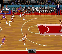 A basketball court viewed from above in a red and wood-grain color scheme. Two teams of pixelated player sprites are positioned across the court during active play. The court features a center circle and three-point line in yellow. A scoreboard displays score 1-9 in the lower left corner. Spectators fill bleachers along the top and sides of the court. The interface shows player jersey numbers and basic game information in the UI at the bottom.