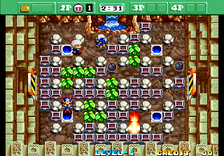 A Bomberman-style maze level displays a brown dirt-textured playing field bordered by wooden crate walls on all sides. Green soft blocks fill the center grid, with several blue enemy characters scattered throughout. A blue player character stands near the center-bottom area. White bomb explosions and fire effects are visible on multiple tiles. The top UI strip shows a green bar with score counters, player indicators marked with numbers, and remaining time. Pixel-art sprites use bright primary colors against the muted brown and green palette typical of mid-1990s arcade hardware.