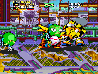 A baseball stadium scene displays three large character sprites in the center foreground—a green alien, a white creature in the middle, and a yellow character on the right—engaged in action. A purple baseball bat is visible in the lower left. The background shows red and purple stadium architecture with a tiled floor pattern in green and purple. Score displays appear at the top of the screen showing player scores. Colorful pixelated sprites and bright primary colors dominate the composition, typical of early 1990s arcade graphics.