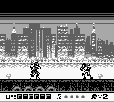 A monochrome Game Boy screenshot displays a ninja character in the center-left of a scrolling platformer level. A detailed cityscape skyline occupies the upper portion with tall buildings in grayscale. The ninja stands on a segmented platform spanning the middle of the screen. Below the gameplay area, a status bar shows health, lives, and score information in pixelated text. Enemies or obstacles appear as small sprites throughout the level. The overall image uses the typical limited palette and resolution of original Game Boy hardware.