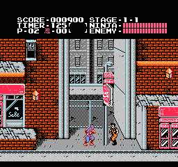 A blue-clad ninja protagonist stands in an urban street level framed by brick buildings and metal scaffolding structures. The score display at top shows 990900 points with stage 1 and energy bar indicated. Pink neon storefront signs flank both sides of the narrow street. The sprite-based graphics use red brick textures, gray metal framework, and a limited NES color palette. A small enemy figure appears in the middle distance near the central building structure.