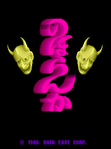 A vertical stack of bright magenta rounded shapes occupies the center of a black background, flanked by two yellow skull heads with horns on either side. The magenta form creates a totem-like silhouette composed of stacked organic segments. Copyright text reading "© 1986 DATA EAST CORP." appears in green at the bottom. The pixel art uses a limited color palette of hot pink, yellow, and black characteristic of mid-1980s arcade graphics.