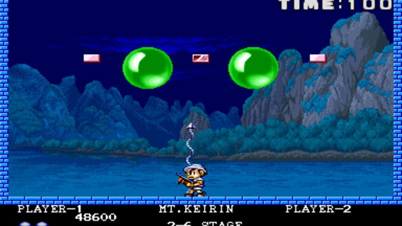 A small player character stands on a blue platform at the bottom center, aiming upward with a weapon that fires a white stream. Two large bright green spheres float in the upper portion of the screen against a dark blue night sky. Rocky mountains and water form the background with teal and gray pixel art. Red and white flags appear scattered across the upper area. The UI displays "PLAYER-1" with score 48600 on the left, "MT.KEIRIN" in the center, "PLAYER-2" on the right, and "2-6 STAGE" below, with "TIME 100" visible in the top-right corner.