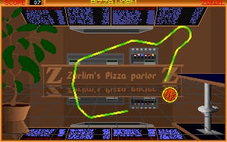 A yellow neon-outlined worm curves across a brown interior space labeled 'Slim's Pizza parlor' in a pizza restaurant setting. The scene features retro low-resolution graphics with a potted plant in the upper left, wooden furniture and fixtures in the background, and a score display at the top showing the game's interface. The UI includes colored panels at the top and bottom edges with blue text elements, and a circular orange object appears in the lower right area of the screen.