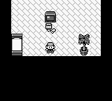 A Game Boy screen displays a trainer battle scene with a checkered background. A player character sprite stands on the left side wearing a red cap, while two opponent trainer sprites are visible on the right—one appears to be a gym leader or rival in black and white clothing, and another figure stands nearby. The screen uses the characteristic monochrome green palette of Game Boy hardware, with low-resolution black sprites and simple geometric background patterns typical of early Generation I Pokémon games.