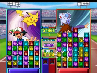 A split-screen puzzle gameplay view shows two active match-three boards with colored gem tiles arranged in columns. The left board displays Pikachu in the upper-left corner amid falling electric effects, while the right board shows a white Pokémon with green energy streaks. Both boards feature purple, red, blue, yellow, and green gem pieces. A stadium background with field lighting and crowd seating fills the upper portion. UI elements include stage indicators, score displays showing numbers like 1440 and 1070, and turn counters. The visual style uses bright colors and sprite-based graphics typical of Nintendo 64-era puzzle games.
