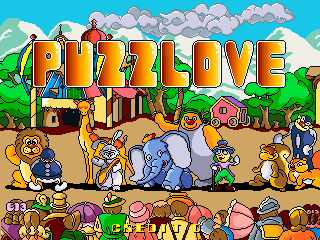 The title screen displays "PUZZLOVE" in large colorful letters across the top, rendered in a bright pixelated font with orange, yellow, and red hues. Below the title, cartoon animals including bears, a dog, and an elephant stand on sandy ground with green vegetation visible on either side. The sky is bright blue with white clouds. A row of smaller pixel-art icons and UI elements appears at the bottom of the screen, including what appears to be score or game information displays. The overall art style uses 16-bit sprite graphics with a vibrant color palette typical of 1990s arcade games.