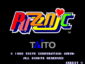 The title screen displays "Puzznic" in large, multi-colored letters with a red heart symbol above it, rendered in a bold arcade style. Below the logo, "TAITO" appears in blue text, followed by white copyright text reading "1989 TAITO CORPORATION JAPAN" and "ALL RIGHTS RESERVED." At the bottom, the word "CREDIT" is shown in white text on a black background. The overall design uses bright primary colors against a solid black backdrop, typical of late 1980s arcade game presentation.