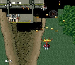 A vertical-scrolling shooter displays a player aircraft in the lower-center of the screen, colored yellow and red, positioned above a green landscape with sand-colored terrain patches. Enemy formations appear in the upper portion against a dark sky with scattered yellow lights. The HUD shows a score of 20650 in the upper-left corner and a B-4 weapon indicator in the lower-left. The graphics use 16-bit sprite art typical of early 1990s SNES arcade conversions, with parallax scrolling visible in the multi-layered background.