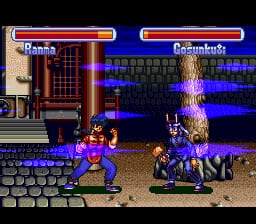 A fighting game battle screen displays two characters facing each other on a brown street stage with blue and purple neon signage in the background. The left character wears purple clothing, while the right character is dressed in dark attire. Health bars appear at the top of the screen in red and blue, with character names displayed above them. The sprite work shows typical 16-bit pixel art resolution with a limited color palette. Stage elements include brown building structures on the left side and what appears to be neon shop signs or storefronts creating the urban setting.