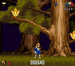 A blue-clad character stands in a forest environment with two large, gnarled tree trunks dominating the center and right side of the screen. The background shows a dark purple night sky with green foliage visible in the upper portion. Two golden shield or medallion icons float in the upper-left and upper-right areas. The HUD displays a score of 000640 in the lower-center and a life counter showing 1 in the upper-right corner. The sprite-based graphics use a 16-bit SNES resolution with earthy browns for the trees and a dark, atmospheric color palette overall.
