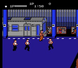 A blue-tinted street scene shows a subway train car in the center with three player characters positioned on the purple pavement below it. The HUD displays health points and time at the top left, with a score panel visible in the upper right. Pixel-art sprites represent the characters in 8-bit style against a tiled brick background. The train and surrounding architecture use a gray color palette, creating contrast with the vibrant blue and purple environment.