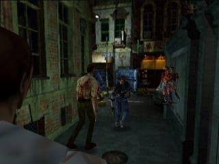 A player character in a blue outfit stands in the center of a narrow alleyway at night, with brick buildings lining both sides. Two zombie-like enemies are visible in the middle distance ahead. The perspective is from a fixed third-person camera angle. Low-resolution 3D polygon models and pixelated textures are characteristic of the N64 platform. Dim lighting creates dark shadows along the alley walls, with a faint light source visible further down the street.