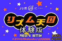A colorful title screen features large orange and black Japanese characters in the center against a bright purple background scattered with white and orange stars. Below the main title text reads "体験版" (trial version) in white, followed by "PRESS A BUTTON" and additional small text in the lower right corner. The overall aesthetic uses bright primary colors typical of GBA sprite-based graphics, with a festive, game-show-like visual presentation.