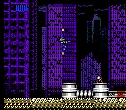 A cyberpunk cityscape dominates the screen with tall purple-outlined buildings rendered in neon tones against a black background. In the center foreground, a white-and-gray mechanical suit with a yellow visor stands on a beige platform. Two cylindrical tanks or containers sit beneath the character on the ground level. The architecture uses repeating vertical line patterns to create the building facades, characteristic of NES-era sprite limitations. The color palette is dominated by purple, blue, black, and white pixels, creating a distinct cybernetic aesthetic.