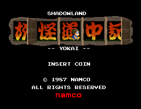 The title screen displays 'SHADOWLAND' in large orange and red pixelated characters at the top center, with Japanese kanji characters visible within the lettering. Below the title appears '-- YOKAI --' in smaller white text. At the bottom, white text reads 'INSERT COIN' followed by copyright information stating '© 1957 NAMCO' and 'ALL RIGHTS RESERVED' with the Namco logo in red. The background is solid black, and the overall design uses an arcade cabinet-style visual presentation typical of 1987 arcade title screens.