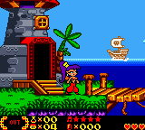 A sprite-based platformer level displays a character in the center of the screen wearing a red outfit, standing on green grass. A red stone tower with a lit window occupies the left side, with a palm tree behind it. A blue water body stretches across the bottom third of the image. A yellow boat with a flag floats on the water to the right. The HUD shows a score of 12300 at the bottom left and what appears to be item or ability icons. The background features a bright blue sky with a scrolling parallax effect. The pixel art uses a vibrant color palette typical of early 2000s handheld game graphics.