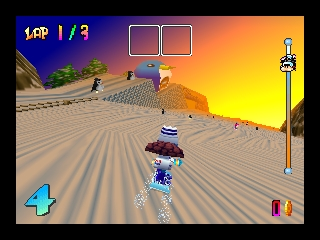 A snowboarder in a blue outfit performs a trick mid-air on a sandy desert slope during sunset. The HUD displays lap 1 of 3 in the upper left, with item boxes at top center and a blue booster icon (number 4) on the lower left. The background shows a warm orange and yellow gradient sky with distant mountains and palm trees. A second snowboarder and various track elements are visible on the sloped terrain below. The game uses a low-polygon 3D art style typical of Nintendo 64 graphics.
