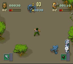 A top-down isometric combat scene displays a single soldier sprite in khaki uniform at screen center, surrounded by a tan-brown ground with green bushes scattered on both sides. Two enemy robots—one blue and one gray-silver—stand on the right edge. The HUD shows two player panels at the top with health bars in red, score counters (00030 and 00110), and ammo displays. Small weapon/inventory icons appear in the bottom corners, rendered in the Bitmap Brothers' characteristic pixelated isometric style with muted earth tones.