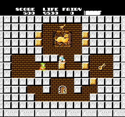 A maze-like level layout fills the screen with white brick walls arranged in a symmetrical pattern on a black background. A small wizard sprite stands in the center-lower area, surrounded by brown stone platforms and doorways. Yellow and brown treasure chests or blocks are scattered throughout the maze at various positions. The top of the screen displays white text showing score, life count, and energy bar. The pixel art uses an 8-bit NES visual style with limited color palette of white, brown, yellow, and black.