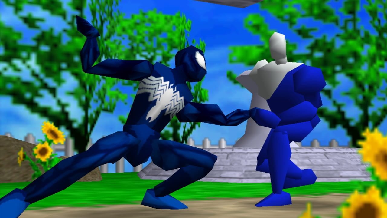 Two dark blue characters face each other in a fighting stance on a grassy outdoor stage. The character on the left wears a white lightning bolt symbol on its chest and has one arm extended. The character on the right holds a white star-shaped object. Green trees form a dense background, with yellow flowers visible in the lower foreground corners. A gray fence and stone structure appear in the mid-distance behind the fighters. The sky is bright blue with soft clouds.