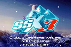 The SSX 3 title screen displays the game logo in large cyan and red lettering centered against a blue sky background with a snowboarder performing an aerial trick. White particles fall across the scene, and a copyright notice for 2003 Electronic Arts Inc. appears at the bottom along with "PRESS START" text. The art style uses 3D graphics typical of early 2000s handheld gaming, with a winter sports theme prominently featured through the snowy atmosphere and action pose.
