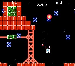 A vertical scrolling space shooter displays a player ship firing upward toward a large red brick structure on the left side of the screen. Multiple blue cross-shaped enemies are scattered across the black starfield background, with a white missile structure in the lower-center area. The score reads 3200 at top-center, with a single life indicator shown in the upper-left corner. Pixelated sprites and a limited NES-era color palette define the visuals.