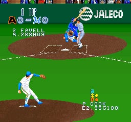 A baseball gameplay screen shows a batter in white uniform at the bottom center, with a pitcher in blue uniform on the mound above. The scoreboard displays team names and player stats at the top in a horizontal layout. The field uses brown infield dirt and green outfield grass rendered in low-resolution SNES sprites. UI elements show score, outs, and player information in small pixelated text. The scene captures an active pitch in progress with typical baseball diamond perspective.