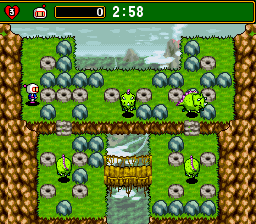 A split-screen two-player view shows a top-down maze level with green grass, brown brick walls, and blue-and-white destructible blocks. The upper half displays player one's perspective with a small bomberman sprite and scattered soft blocks; the lower half shows player two's view of the same arena from a different angle. A wooden structure with a roof occupies the center. The HUD displays a timer reading 2:58 at the top. Pixel art sprites and 16-bit color palette are typical of SNES-era graphics.