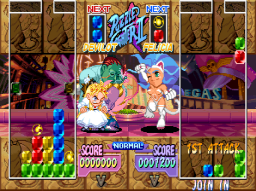 Two cartoon characters sit facing each other on a pink stage with purple brick walls in the background. The screen displays a split-panel puzzle-fighter layout with four game boards arranged around the center—two on the left showing stacked colored blocks and two on the right. At the top, "NEXT" indicators flank the game title in blue. Score readouts appear below each character, both showing zero points and "NORMAL" difficulty. UI elements include "1ST ATTACK" label in the lower right and a "JOIN IN" prompt at the bottom. Colored gems and blocks fill the puzzle boards in vertical columns. The art style features 16-bit pixel sprites against a textured golden background.