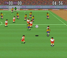 A soccer match in progress on a green field with two teams in orange and red jerseys positioned across the pitch. A white ball is visible in the center area. The scoreboard at the top displays 0-0 with a game timer showing 04:56. Players are scattered in various formations, with one red-jerseyed player notably positioned in the lower right. The sprite-based graphics show low resolution pixelated players and a simple flat perspective typical of early 1990s SNES sports games.