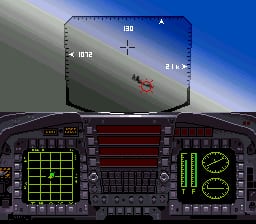 A cockpit view of a military aircraft during flight, with the nose pointed toward a desert landscape below. The HUD display shows altitude, speed, and directional information in the upper portion. The bottom half features a dark instrument panel with a green grid radar display on the left, a central dark strip with various indicators, and a green circular radar scope on the right showing target positions. The exterior sky transitions from blue at the horizon to lighter tones above, with subtle parallax showing terrain details below.