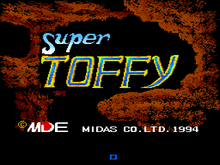 The title screen displays 'Super Toffy' in large yellow and cyan pixelated lettering centered on a black background with an orange and red textured border. Below the title, white text reads '© MDE MIDAS CO.LTD. 1994'. A small blue rectangular element appears at the bottom center of the screen. The overall color scheme uses high contrast neon colors typical of early 1990s arcade game design.