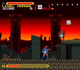 A female character in blue armor stands on a stone platform against a red-orange sunset skyline with tall dark buildings. The HUD displays "LEVEL NORMAL" and "SCORE 0" in the upper left corner with health bars below. Two tall pillars frame the scene, and a yellow horizontal energy bar spans the lower portion of the screen. The background shows a gothic cityscape with silhouetted architecture rendered in dark red and black pixels against a fiery gradient sky.