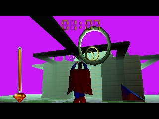 Superman stands in the center wearing his red cape and blue suit against a bright magenta background. A large circular reticle or targeting crosshair hovers above his head. Green rectangular structures resembling buildings or obstacles are positioned to the right and center of the scene. A yellow vertical line appears on the left side. The art style shows N64-era 3D polygonal graphics with flat color fills and limited shading typical of early Nintendo 64 games.
