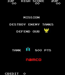 The title screen displays "MISSION" at the center, followed by "DESTROY ENEMY TANKS" and "DEFEND OUR" with a small eagle emblem below. A cyan-colored tank sprite appears in the middle section, accompanied by "TANK" label and "SOO PTS" text. The Namco logo in red is positioned lower on screen. Game information appears at the top with "1UP", "HIGH SCORE", and "2UP" indicators, while "CREDIT 0" is shown at the bottom left. The entire display uses a black background with white and colored text in a classic arcade style typical of early 1980s games.
