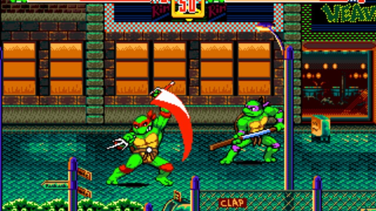 Two green ninja turtles engage in combat on a teal-tiled street. The left turtle wields a red curved weapon while the right turtle holds a brown staff. Orange-windowed brick buildings with green trim form the urban background, with a dark storefront visible on the right side. A health bar spans the top of the screen in red and green. The sprite-based characters display bright primary colors typical of 16-bit Sega Genesis graphics, with the HUD showing combat action against a detailed parallax cityscape.