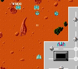 A split-screen display shows the main gameplay area on the left with an orange-brown desert terrain dotted with rocky formations and enemies, while the right side displays a white-bordered HUD panel containing a black monitor graphic, two vertical weapon/power-up indicator columns with cyan-colored icons, and a small aircraft sprite. The score reads 5300 at the top left. Pixel art enemies including red tentacled creatures and dark green tank-like units are scattered across the orange ground.