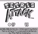 The title screen displays "TETRIS ATTACK" in large pixelated letters at the top center, rendered in a bold blocky font typical of Game Boy graphics. Below the title appears a trademark symbol. At the bottom of the screen, copyright text reads "© 1995 Nintendo/Intelligent Systems" and "TETRIS is a trademark of The Tetris Company" in small monospaced font. The "OF US" text appears in the lower right corner. The background is light gray with black text and sprites, using the limited grayscale palette characteristic of original Game Boy hardware.