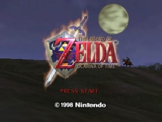The Legend of Zelda: Ocarina of Time title screen displays the game's logo in red and gold lettering at center, superimposed over an image of Link with a glowing sword against a nighttime landscape. A full moon appears in the upper right corner above a silhouetted mountainous horizon. The text "PRESS START" appears in red below the logo, with a Nintendo copyright notice at the bottom stating "© 1998 Nintendo". The background uses a dark purple-blue sky with warm orange lighting effects around the central imagery.