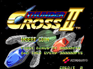 The Thunder Cross II arcade title screen displays the golden logo at the top with a registered trademark symbol. Below, two spacecraft are positioned centrally against a black starfield background. Green text reading "INSERT COIN" appears in the middle, followed by yellow text stating "FIRST BONUS AT 500000PTS AND THEN EVERY 500000PTS." The Konami logo is visible in red in the bottom-right corner. The overall composition uses bright yellow, blue, and green text against a dark space backdrop with pixelated sprite graphics typical of early 1990s arcade games.