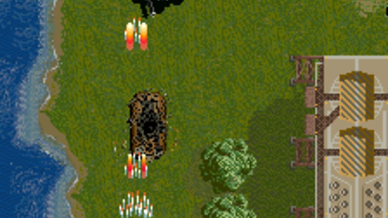 A top-down scrolling shooter displays a brown tank sprite in the center of a grassy field with three clusters of white and red projectile sprites positioned below it. On the left edge, blue water with a sandy beach strip is visible. On the right, a brown wooden structure with yellow and white striped window panels occupies the corner. Two green tree sprites appear in the mid-field area. The HUD panel on the right shows yellow diagonal-striped weapon or power-up icons stacked vertically.