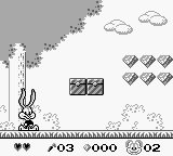 A Game Boy screenshot showing a character sprite on the left side of a platformer level with a gray brick wall background. The HUD displays a score counter reading 7063, a 9000-point value, and a timer at the bottom. Collectible items appear in the upper-right corner, including heart icons and what appears to be a gray crate or obstacle. The scene features monochrome pixel art typical of original Game Boy resolution with simple parallax clouds visible at the top of the screen.