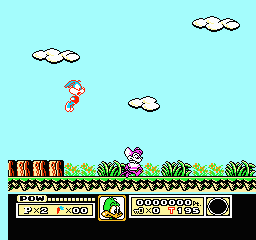 A side-scrolling level displays Buster Bunny as a small blue sprite running along green grass terrain with brown wooden structures. Three white clouds float across a cyan sky at varying heights. The bottom UI panel shows a black status bar with pixel-art icons, numerical readouts, and what appears to be a health or power meter. The art style uses 8-bit NES-era sprite graphics with limited color palettes typical of early 1990s console gaming.