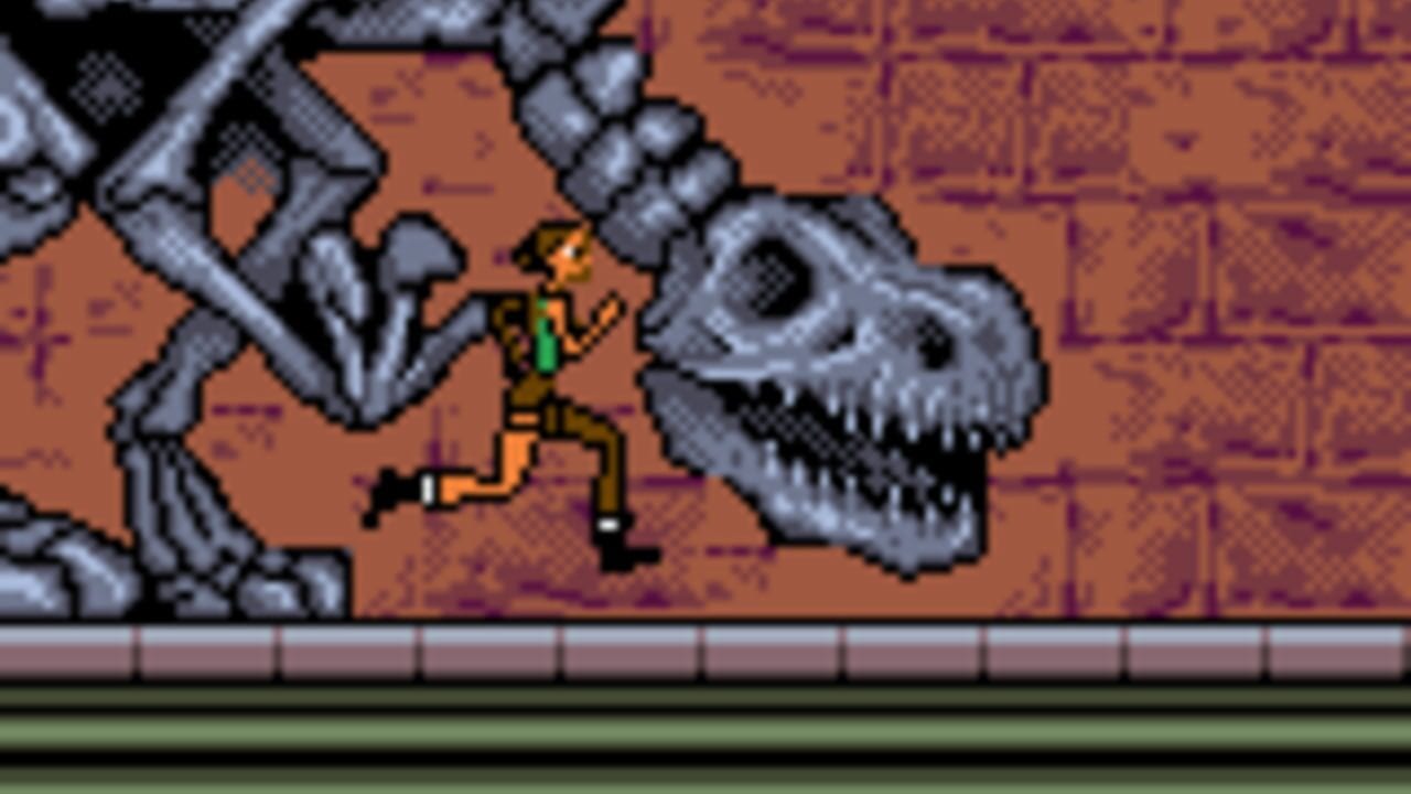 A pixel art scene shows a small character in yellow and green clothing standing between two large skeletal creature heads with gray bone textures. The creatures flank the character on a platform with a brown and purple textured background. A horizontal bar divides the scene at the bottom, with green and gray horizontal lines creating a UI element. The sprite-based graphics use a limited color palette typical of Game Boy hardware.