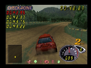 A red rally car drives on a dirt track through a forested mountain landscape with evergreen trees lining both sides. The HUD displays lap times in the upper left corner, a speedometer showing 039 mph in the lower right, race position indicator showing second place, and a minimap in the bottom left corner. The sky shows an overcast atmospheric effect with distant terrain visible. The 3D graphics use a low-poly style typical of Nintendo 64 hardware, with flat-shaded surfaces and limited texture detail on the track and vegetation.